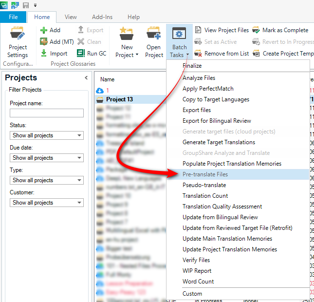 Trados Studio interface showing the 'Batch Tasks' menu with 'Pre-translate Files' option highlighted by a red arrow.