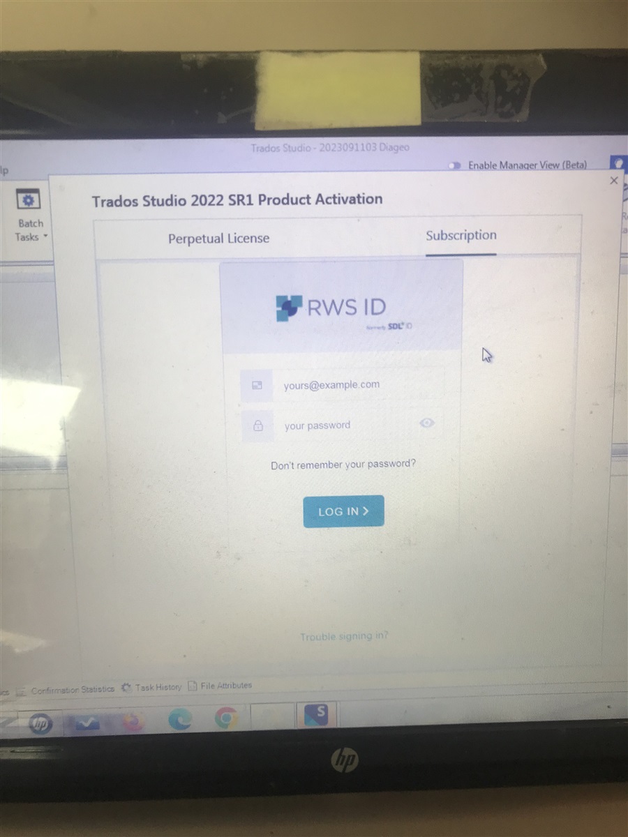 Trados Studio 2022 SR1 Product Activation window with options for Perpetual License and Subscription. Email field and password field visible with 'LOG IN' button and 'Trouble signing in?' link.