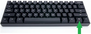 Black mechanical keyboard with an upward green arrow pointing to the 'Enter' key.