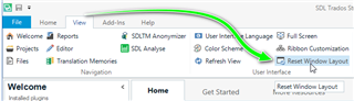 Trados Studio interface with an arrow pointing to the 'Reset Window Layout' option under the 'View' tab in the ribbon menu.