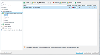 Trados Studio project settings showing an alert symbol next to the TM under All language pairs with a message about different translation memories for certain language pairs.