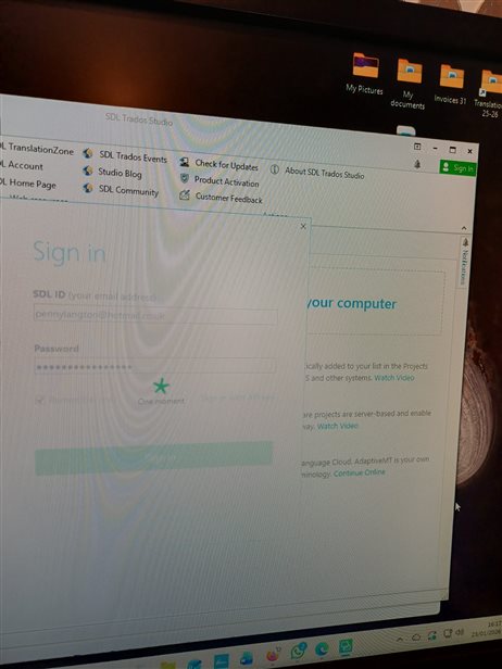 A login screen in SDL Trados Studio showing fields for SDL ID and password, with a spinning icon indicating a loading process.